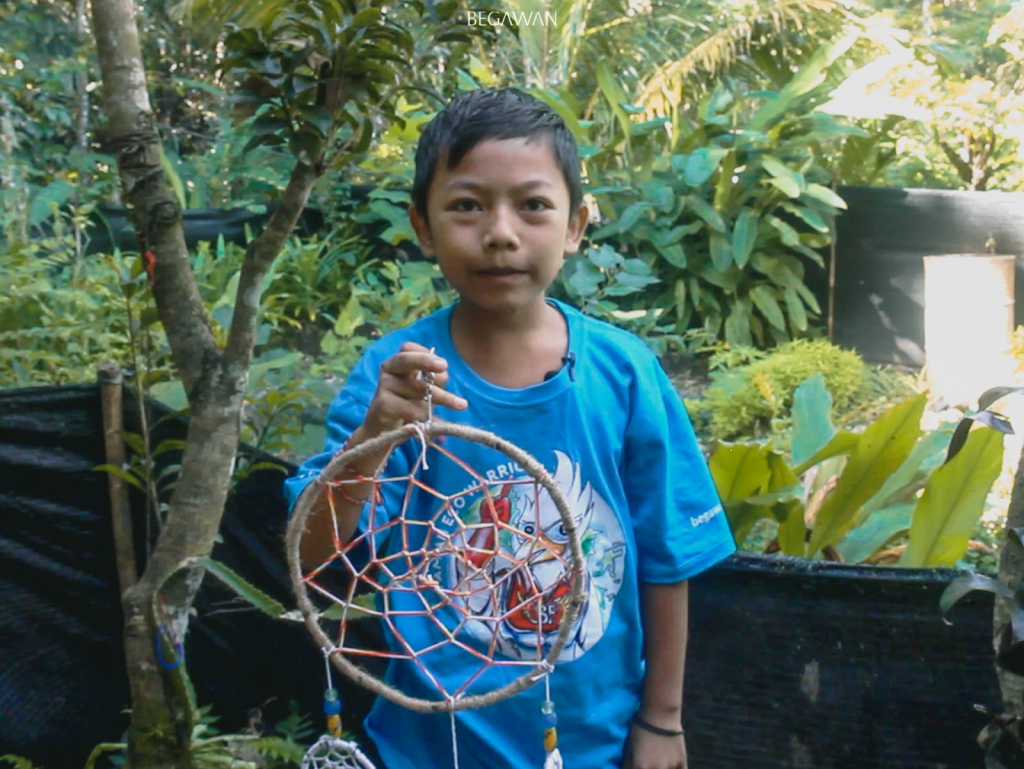 Student demonstrating a dream catcher that his team created.